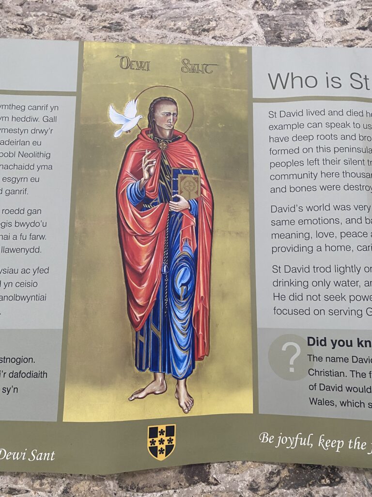 Sign from wall of Cathedral with painting of Dewi Sanc with gold background