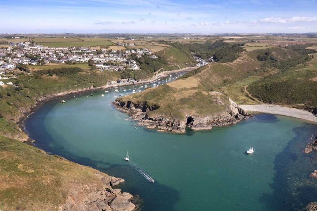 Aerial view of Solva harbour, blue sea, beach and boats in harbour, houses of Solva