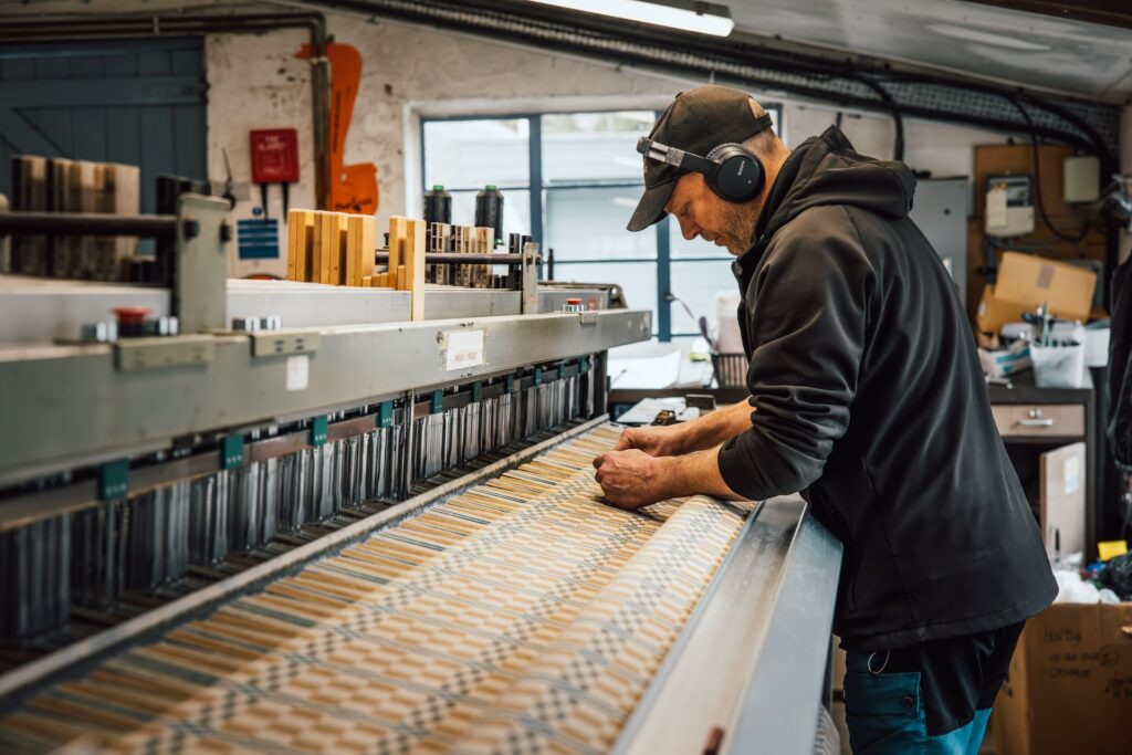 Man working weaving machine making Welsh wool blanket at Melin Treqwynt mill