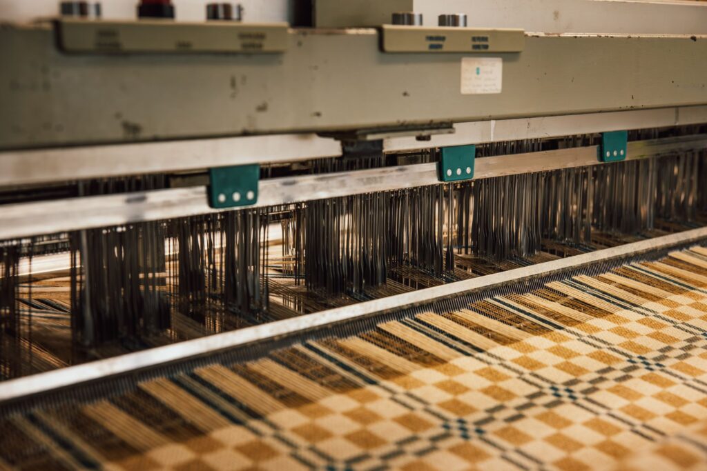 A yellow Welsh wool blanket being woven on machine